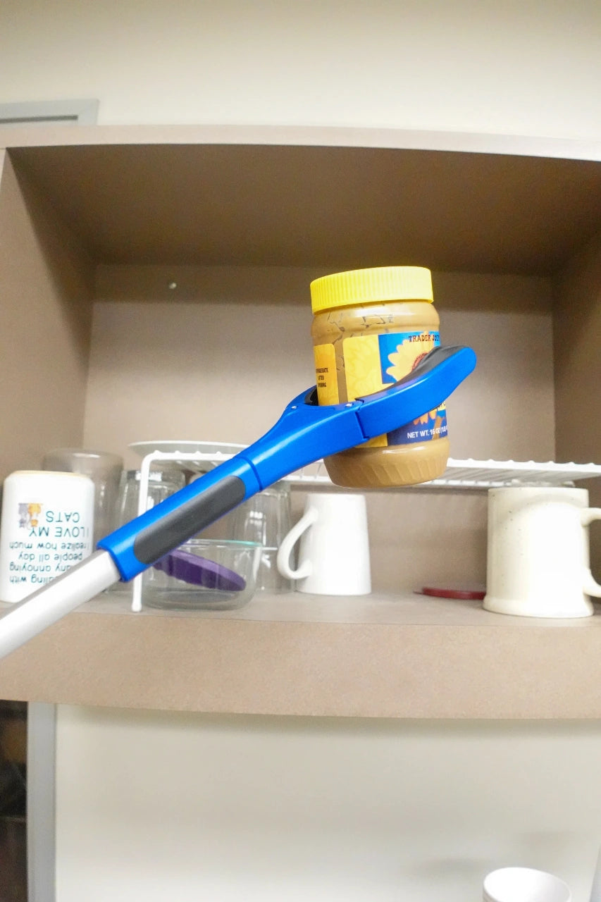 Blue plastic tool lifting a jar of peanut butter from a kitchen shelf.