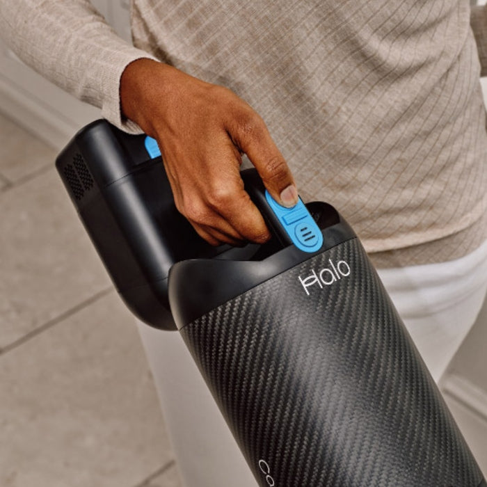Person holding a Halo Capsule X Stick Vacuum Cleaner, close-up view.
