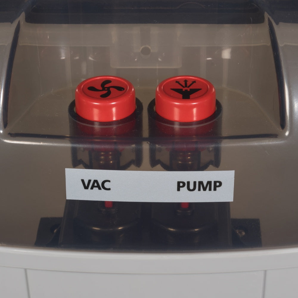 Two red buttons labeled 'Vac' and 'Pump' on a machine.