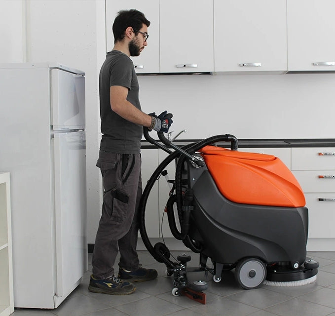 Person using a TSM Grande Brio 50B Scrubber Dryer machine in a kitchen