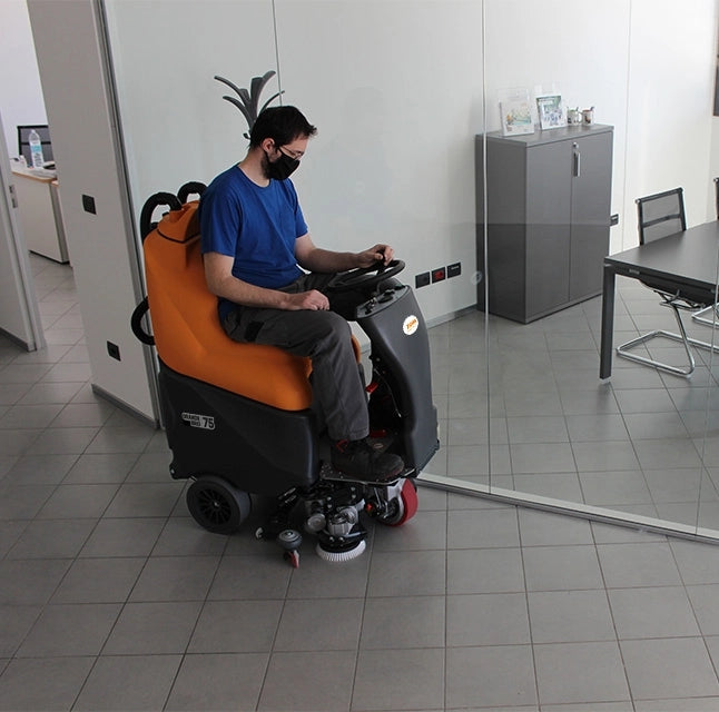 Person operating a TSM Grande Brio Ride On 75-650 Scrubber in an indoor setting