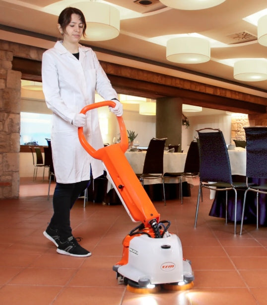 Person using a TSM Willmop 35 Scrubber Dryer cleaning machine in a restaurant setting