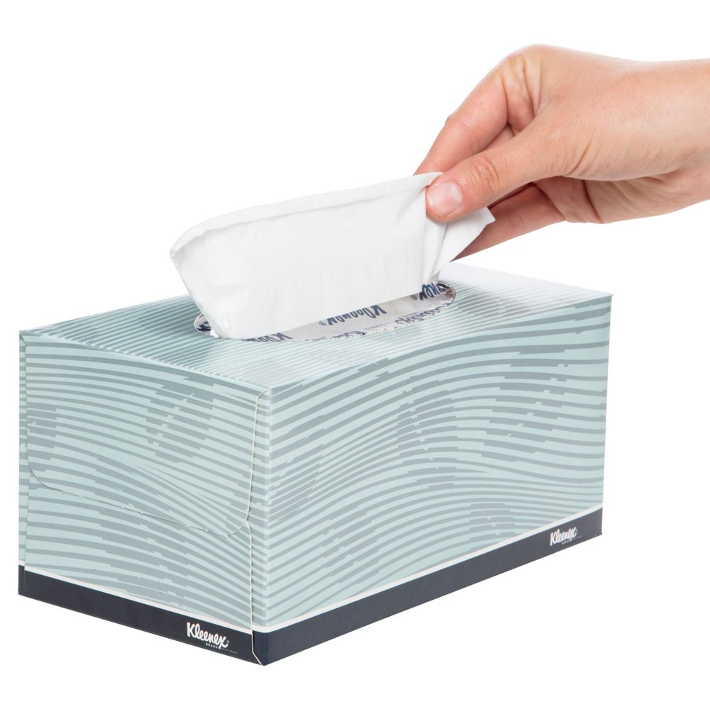 Hand pulling a tissue from a Kleenex box on a white background