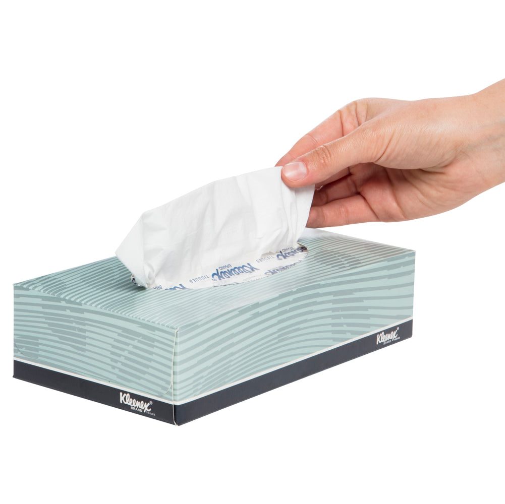 Hand pulling a Kleenex tissue from a box on a white background