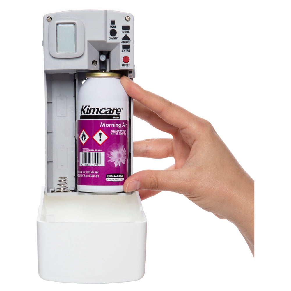 Hand holding a Kimcare 'Morning Air' spray can over a dispenser.