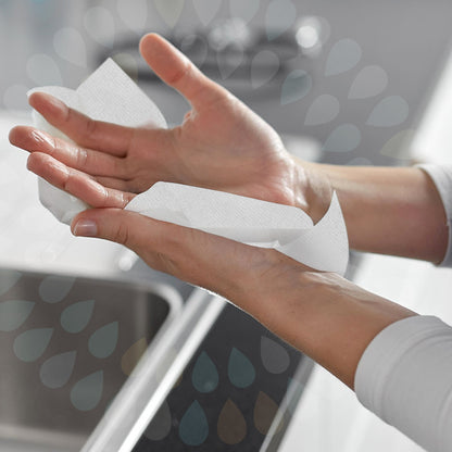 Person using a white paper towel to dry hands with a blurred background