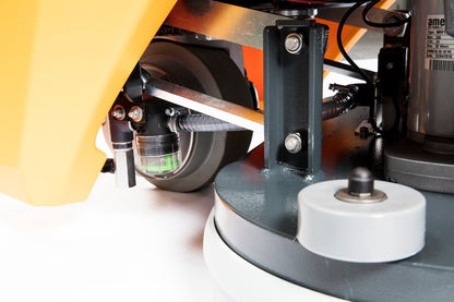 Close-up of a scrubbing machine with wheels and mechanical components on a white background