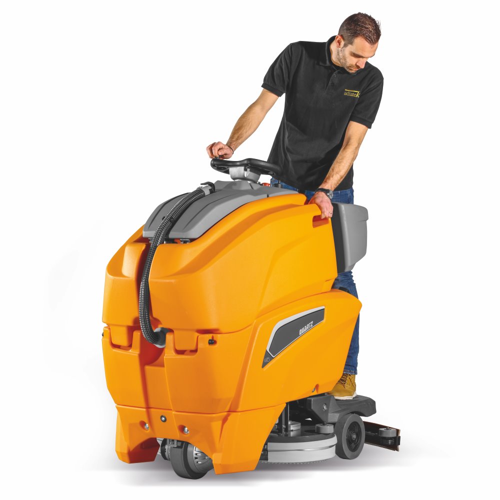 Man operating a large orange Adiatek cleaning machine on a white background