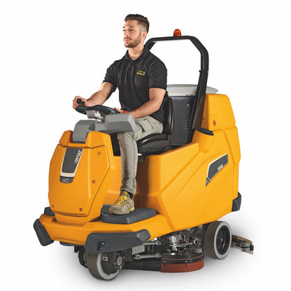 Person operating a yellow Adiatek Topaz 90 Ride On Auto Scrubber floor cleaning machine on a white background