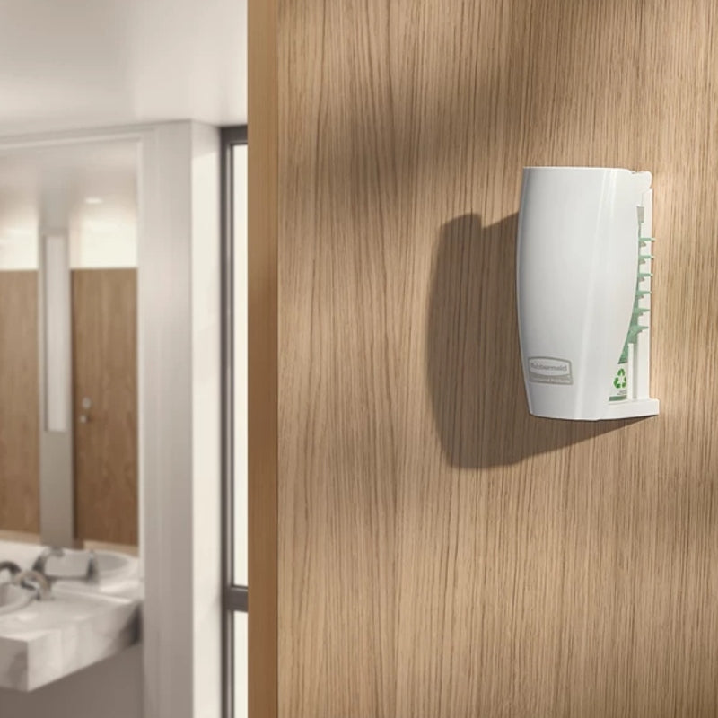 White air freshener dispenser mounted on a wooden wall in a bathroom setting