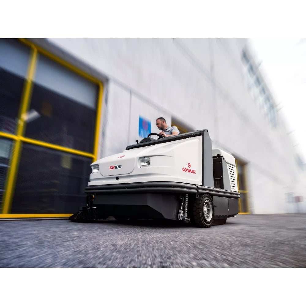 Comac CS120B Ride On Sweeper is use outside with a person behind steering wheel
