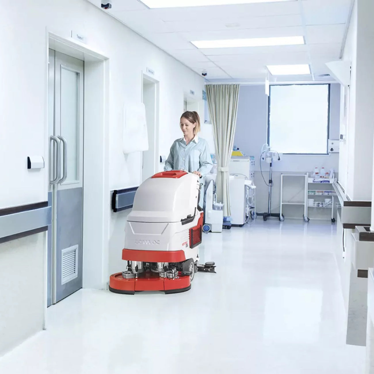 Person operating a floor cleaning machine in a hospital setting