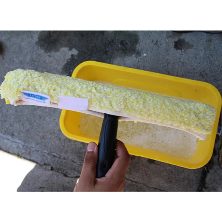 Yellow squeegee with a textured microfiber squeegee held by a hand against a concrete background