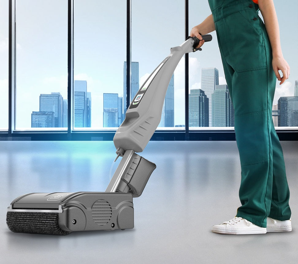 Person cleaning a floor with a vacuum cleaner in an office setting