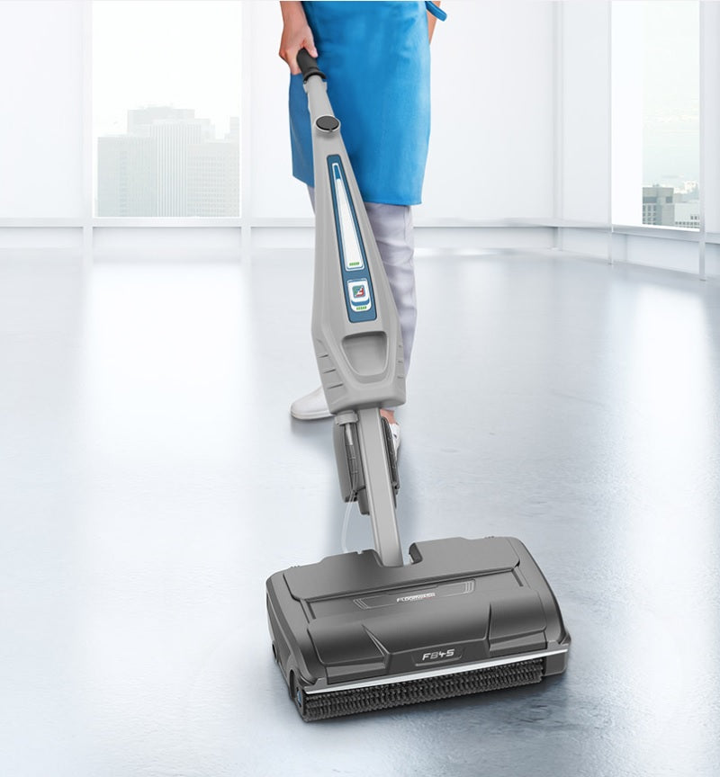 Person using a floor scrubber on a shiny floor