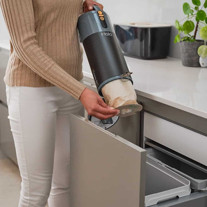 Person emptying a Halo Vacuum Cleaner bag.