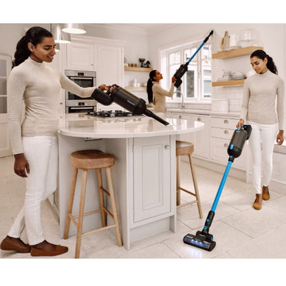 Woman using a Halo Capsule X Stick Vacuum Cleaner in a kitchen