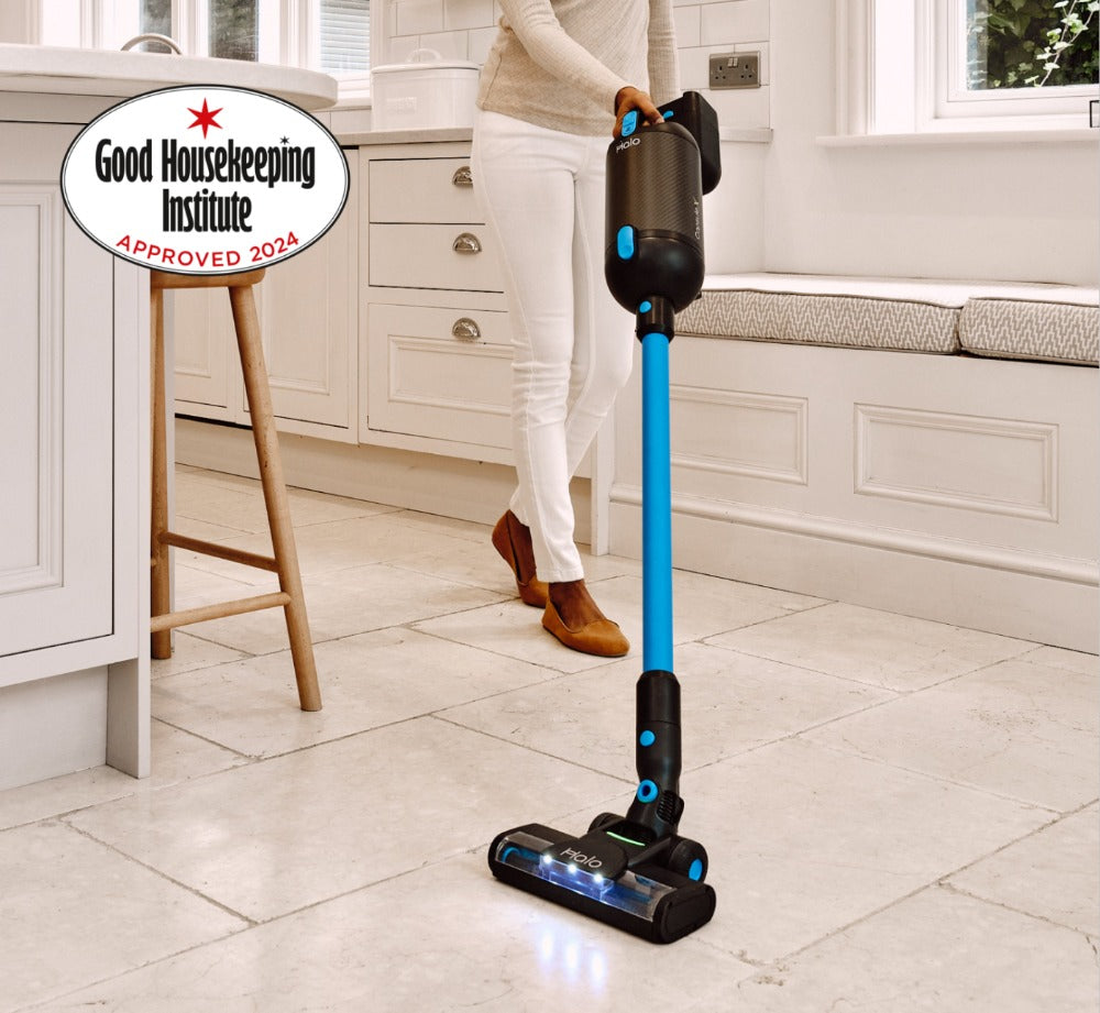 Person using a Halo Capsule X Stick Vacuum Cleaner in a kitchen with Good Housekeeping Institute approval badge.
