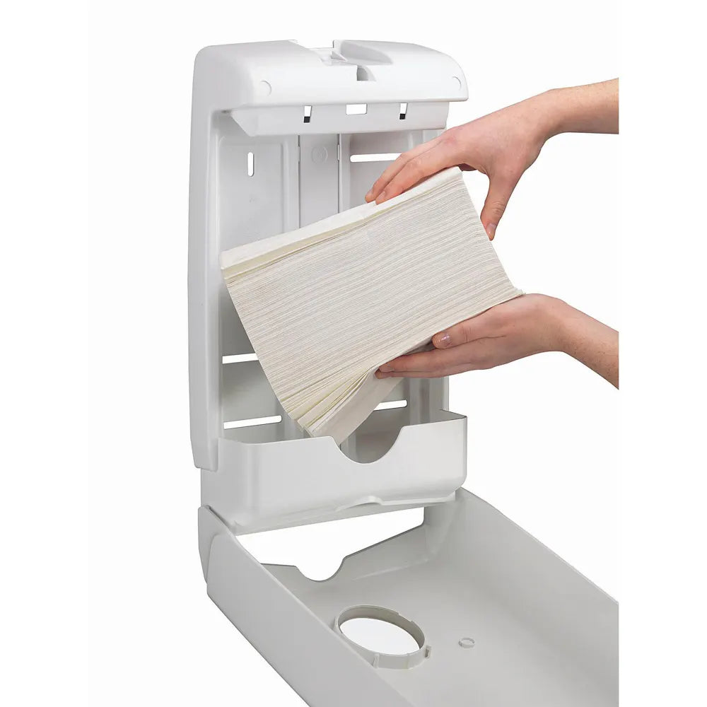 White paper towel holder with a hand pulling out a roll of white paper towels.