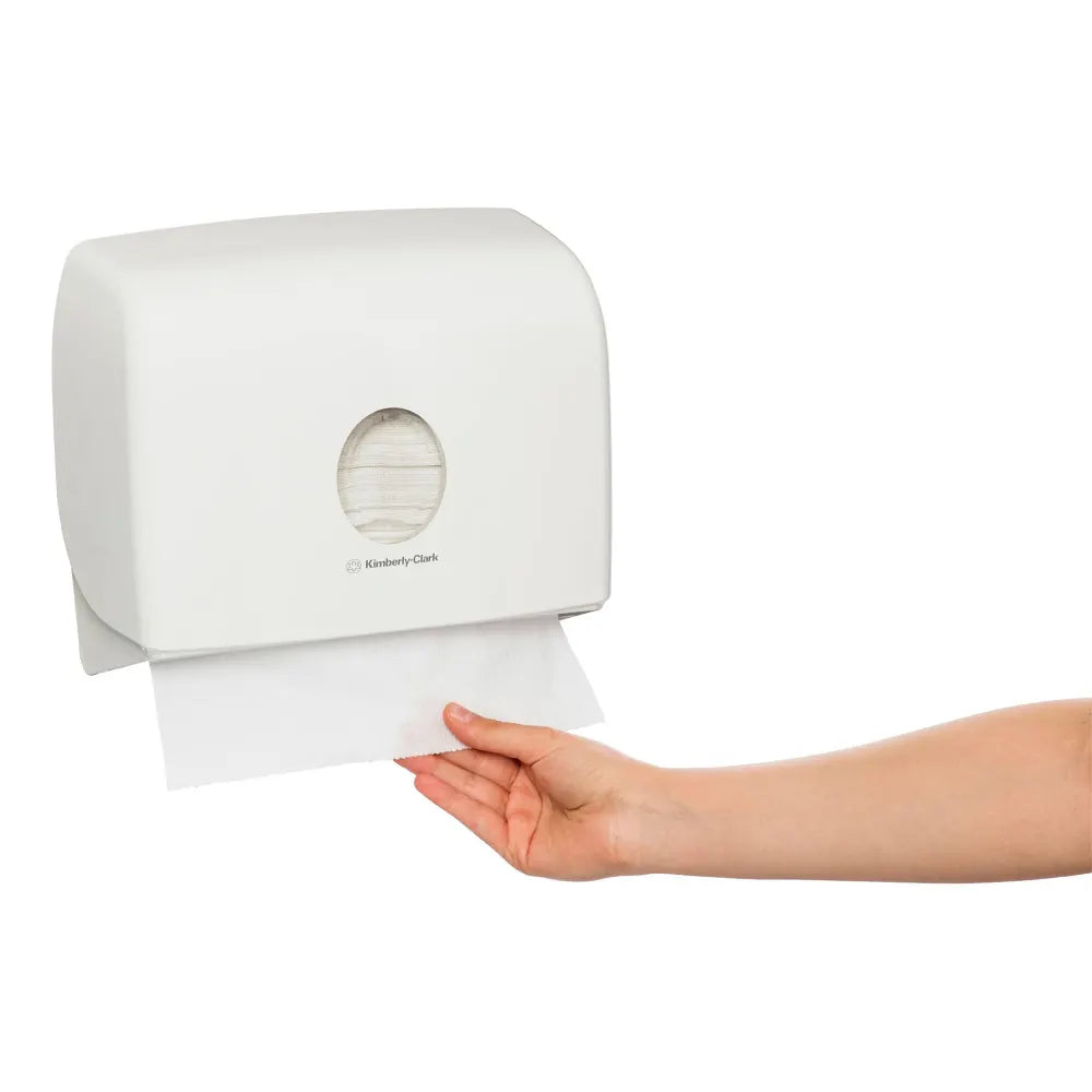 White paper towel dispenser with a hand pulling out a sheet of paper towels.