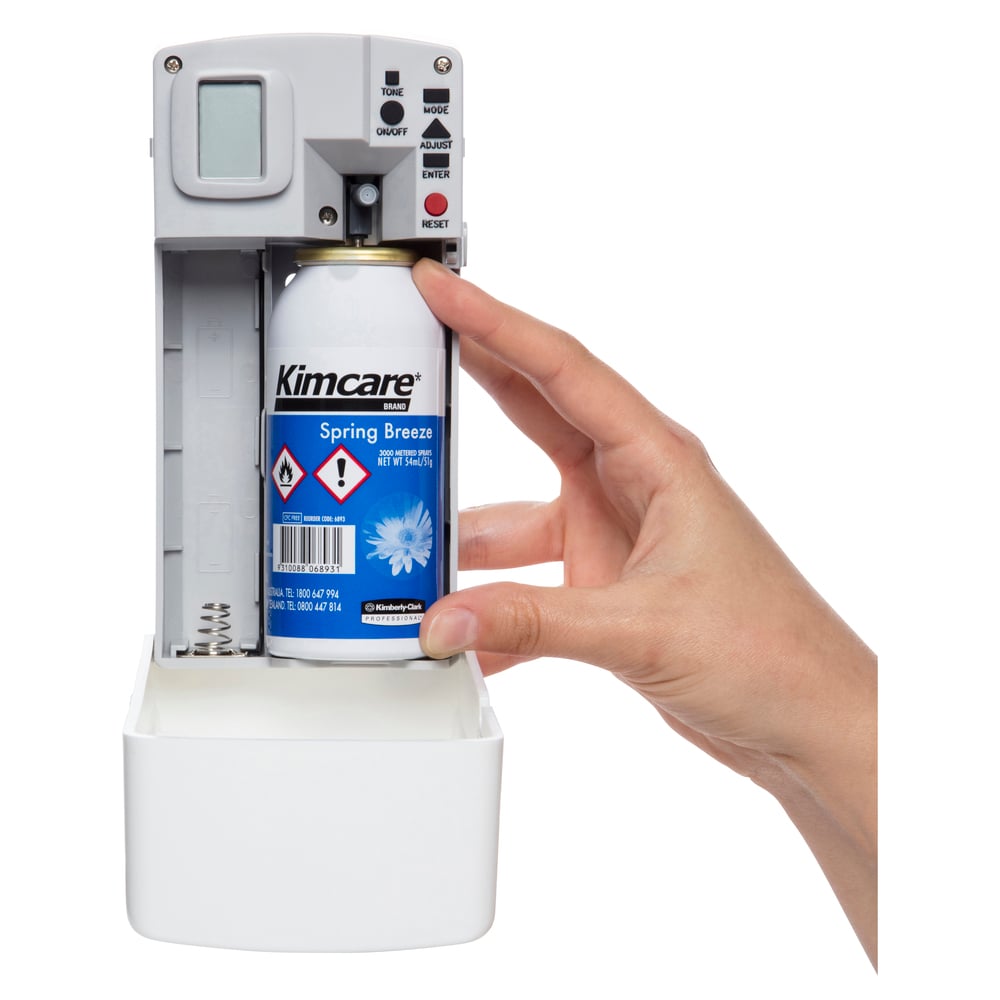 Hand installing a Kimcare Spring Breeze canister into a white dispenser.
