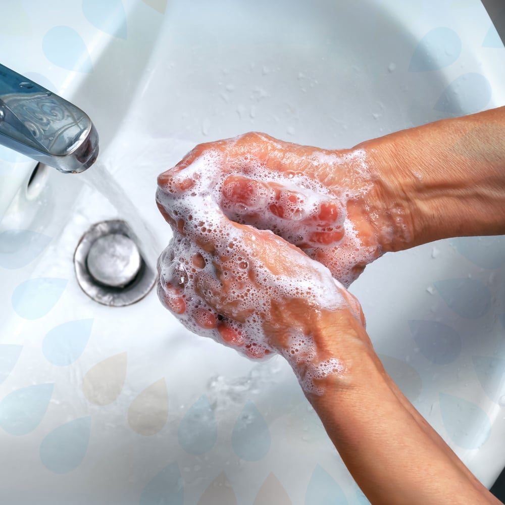 Hands washing with soap under a faucet in a sink