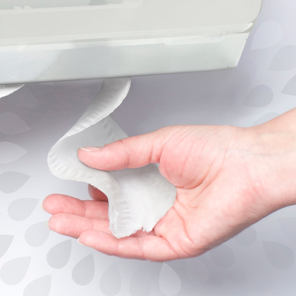 Hand holding a small amount of white toilet paper against a neutral background