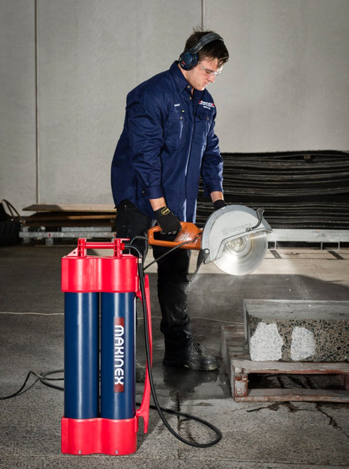 Person using a concrete saw with Makinex Hose 2 Go Water Supply in a workshop setting