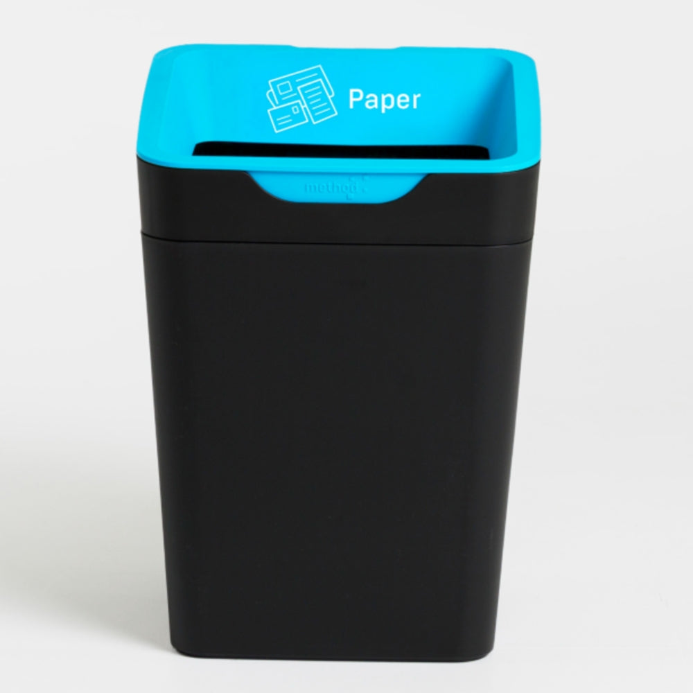 Black trash bin with blue top labeled 'Paper' on a white background