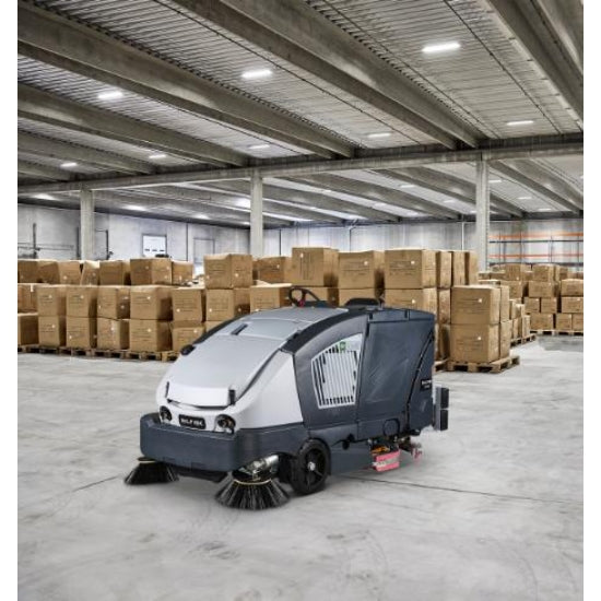 Nilfisk CS7020 Lithium Ion Sweeper Scrubber Dryer in a warehouse with stacked boxes