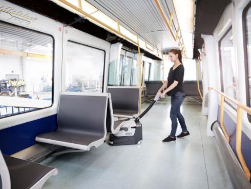 Person cleaning the interior of a modern train with a Nilfisk SC250 Scrubber.