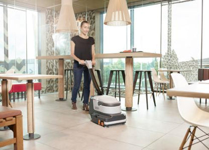 Person using a Nilfisk SC250 Scrubber in a modern restaurant setting
