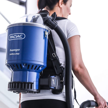 Person wearing a blue Pacvac Superpro battery700 backpack vacuum cleaner.
