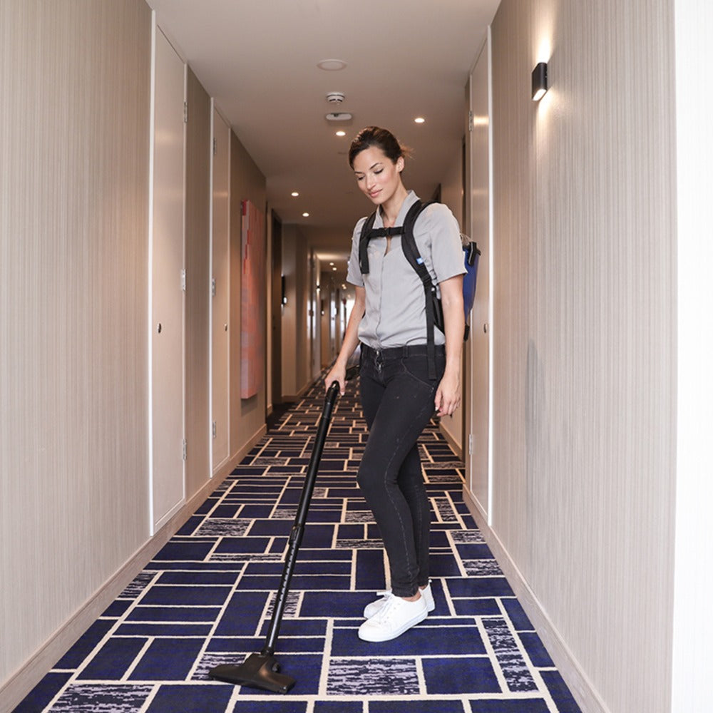 Person cleaning a hallway with a vacuum cleaner