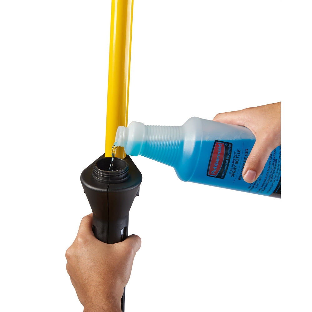 Person pouring a blue liquid from a bottle into a black container with a yellow stick.