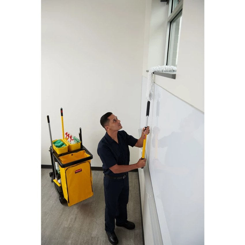 Person cleaning a window sill with a cleaning cart in the background