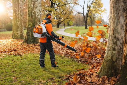 Person using a STIHL Leaf Blower Backpack 2 Stroke in a park with autumn leaves