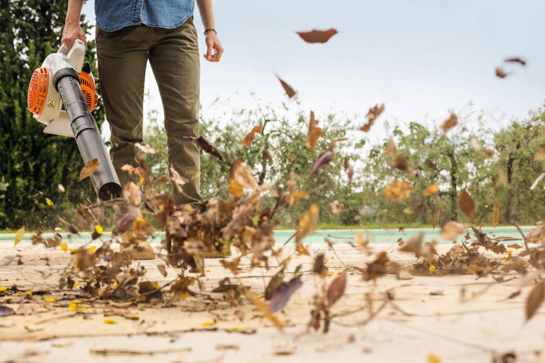 Person using a STIHL Blower Z Petrol leaf blower to clear leaves from a deck
