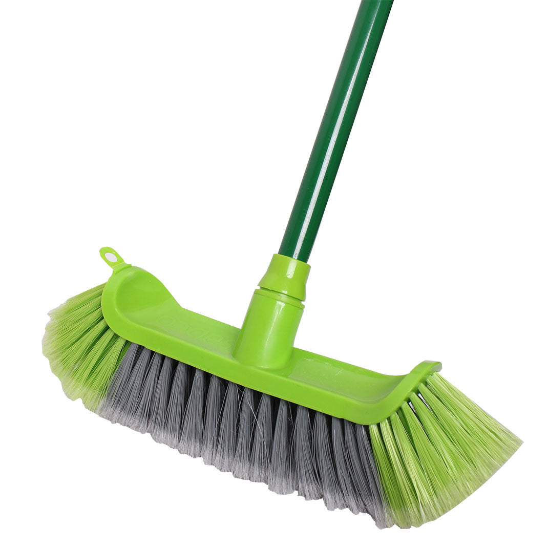 Green broom with a flexible head on a white background