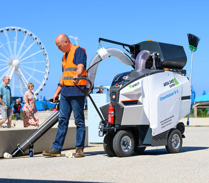 Person operating a large piece of industrial equipment with a Ferris wheel in the background