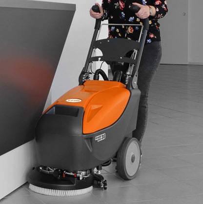 Person using a floor cleaning machine on a tiled floor