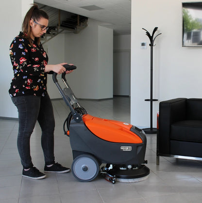 Person operating a floor cleaning machine in an indoor setting