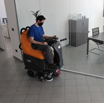 Person operating a TSM Grande Brio Ride On 75-650 Scrubber in an indoor setting