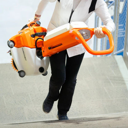 Person carrying a TSM Willmop 35 Scrubber Dryer up stairs.