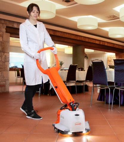 Person using a TSM Willmop 35 Scrubber Dryer cleaning machine in a restaurant setting