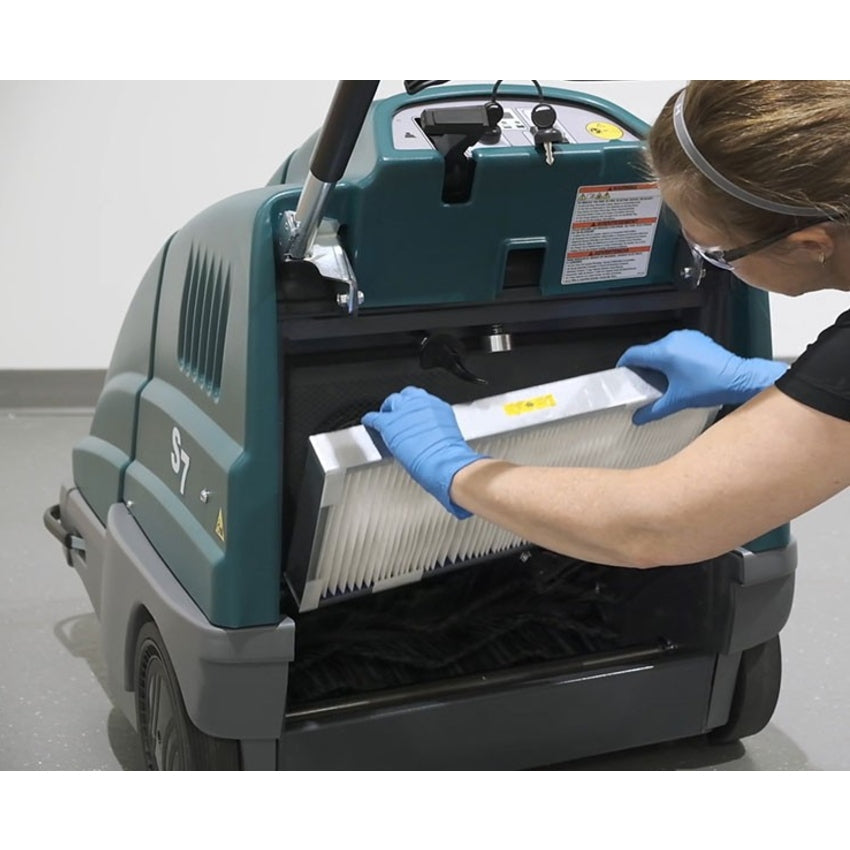 Person cleaning a filter on a Tennant S7 Battery Sweeper