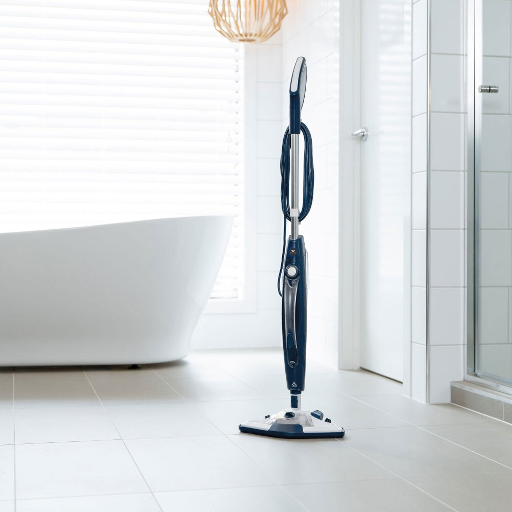 Wertheim Dual Steam Mop Plus on a tiled bathroom floor with a bathtub and shower in the background.