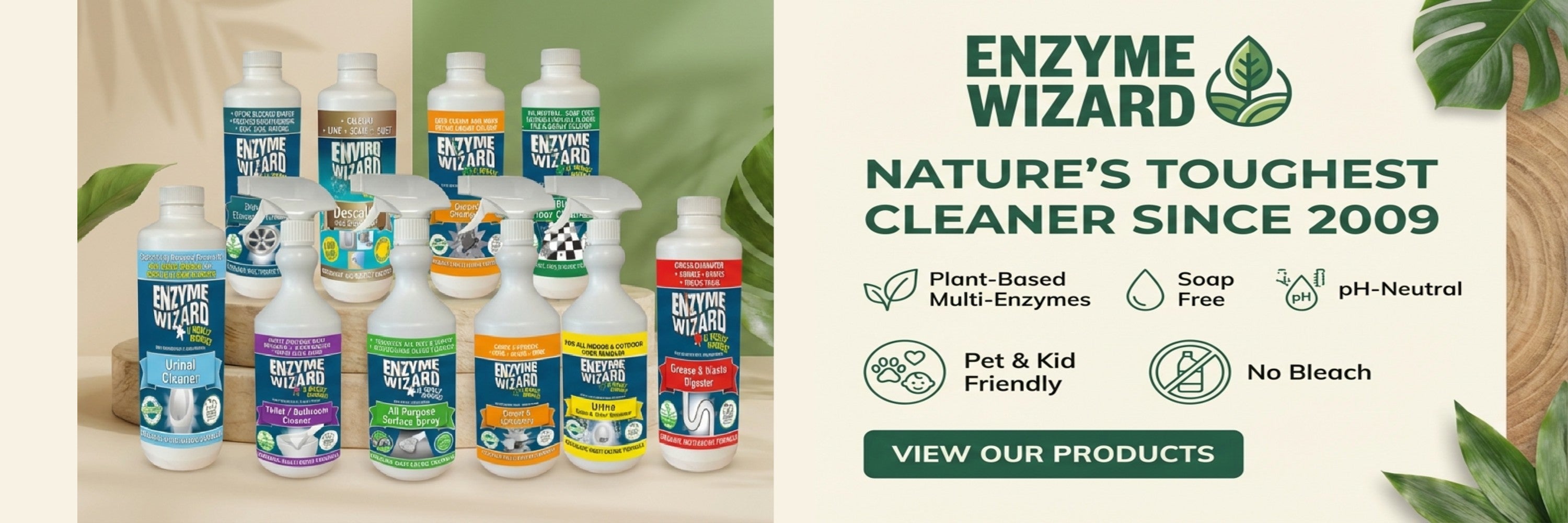 Enzyme Wizard cleaning products with a promotional banner on a wooden surface.